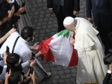 Pope Francis kisses the flag of Lebanon at his general audience on Sept. 2, 2020.
